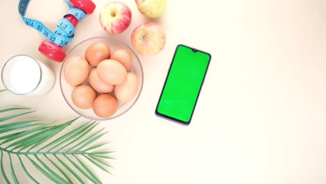 teléfono inteligente con pantalla vacía , huevos , leche y nueces de almendra en la mesa