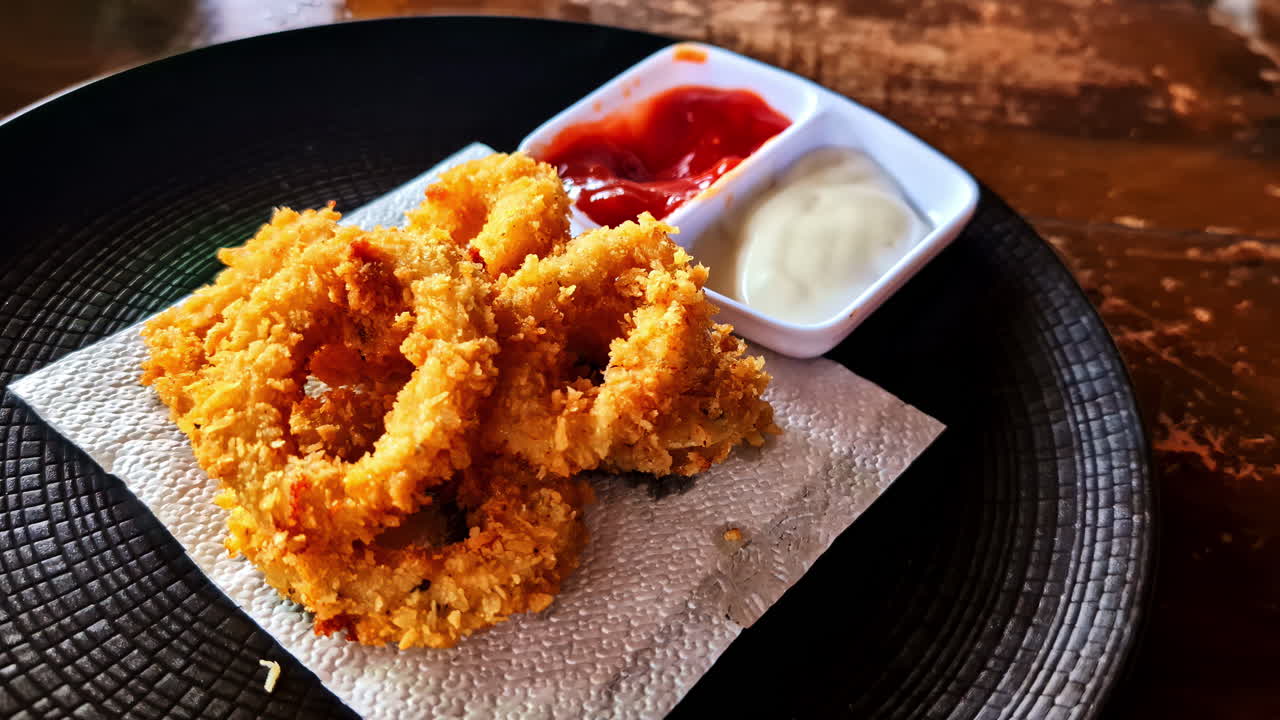 Relaxing at Amed Beach while eating onion rings with dips