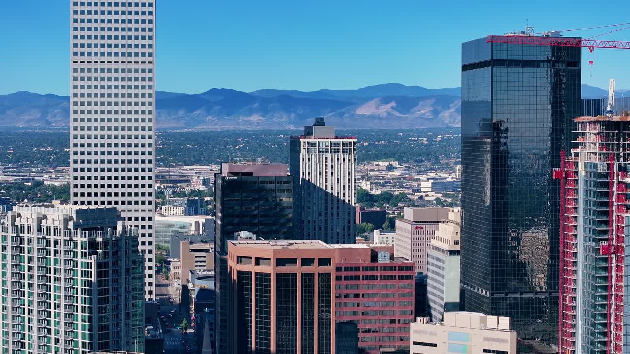 Ripresa di presentazione con drone delle torri di Denver con sfondo del Front Range, discesa aerea con teleobiettivo.