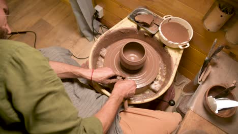 male hands making a clay bowl on a potter's wheel. handicraft and production of exclusive tea ware made of clay