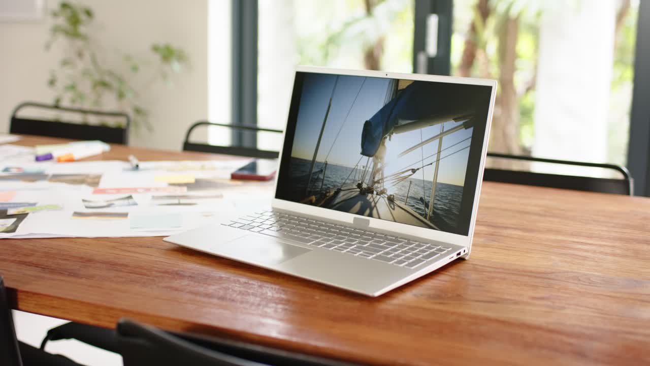 All'avvio della riproduzione, la camera sposta la messa a fuoco da schizzi e note al laptop che mostra una barca a vela
