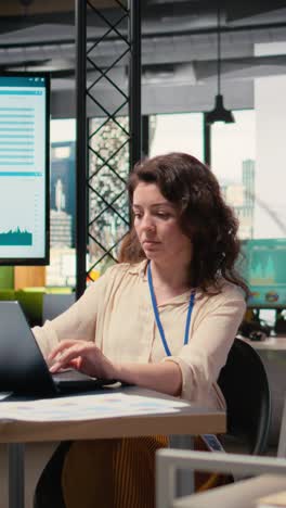 vertical video female general director reviewing data insights on her laptop