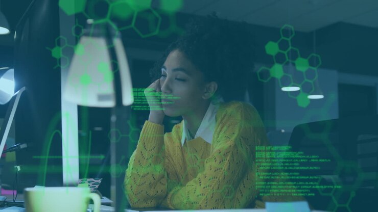 In office, woman in yellow sweater working with digital animation data overlay