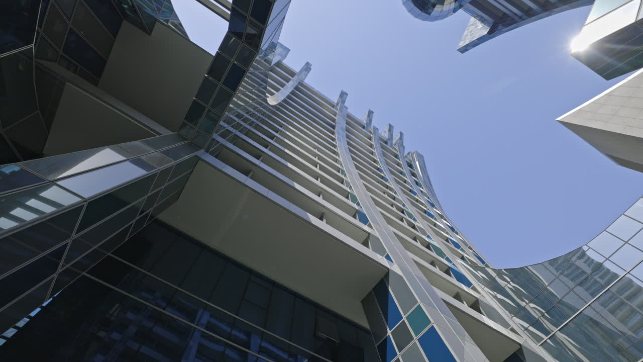 Rascacielos moderno con fachada de cristal bajo cielo azul