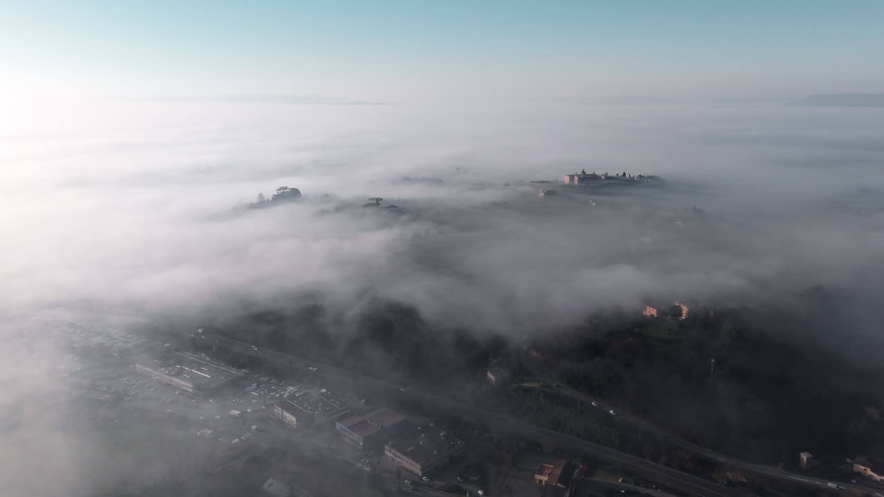 Serene aerial view above misty Siena countryside in Tuscany at sunrise