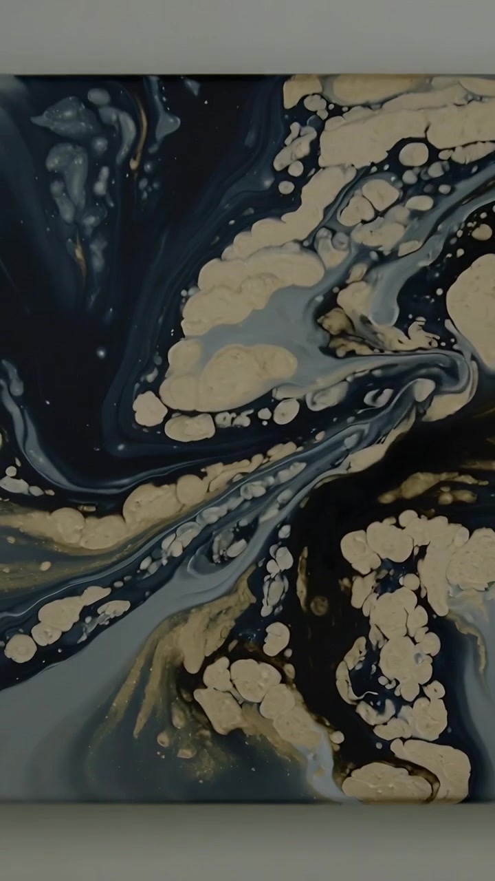 Video verticale: Inizio panoramica, telecamera che si muove su una tela appesa al muro, mostrando celle color crema, riflessi dorati.