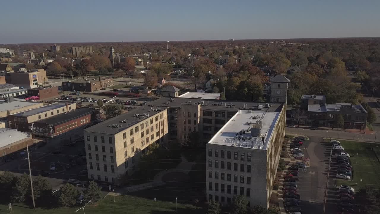 Rotating aerial of buildings and traffic in downtown Muskegon, MI