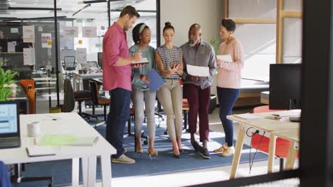 Happy-diverse-business-people-discussing-work-during-meeting-at-office