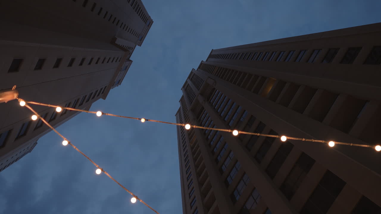 Tall Buildings at Dusk with String Lights