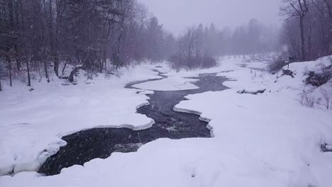 slow motion shot of two icy streams converging during a winter snowstorm