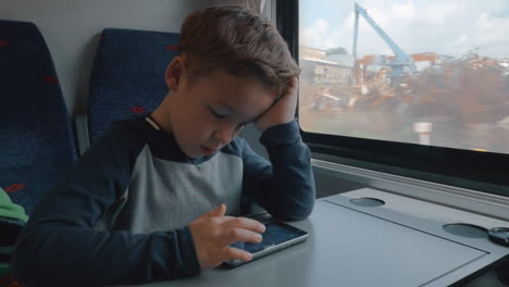 boy using cellphone in train passing by the dump
