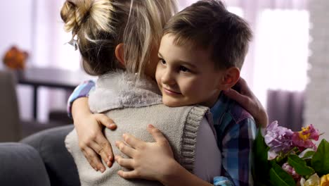 en primer plano, un niño lindo felicitando y abrazando a su madre.