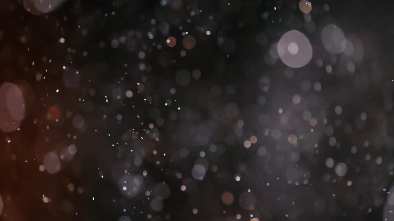 Floating abstract particle bokeh on dark background