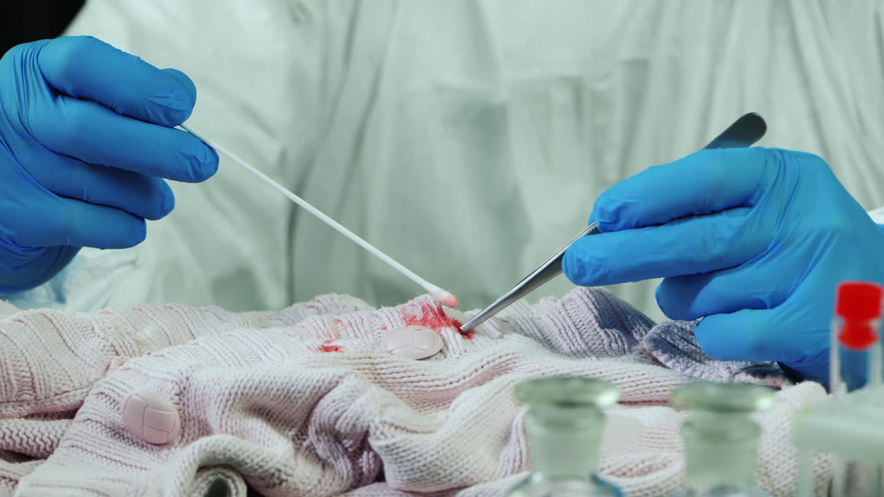 trabajador de laboratorio criminal examina evidencia en ropa 5