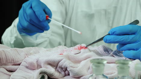 crime lab worker examines evidence on clothes 5