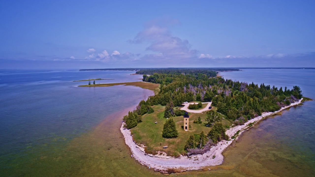 Dronekuva alkaa Stoningtonin niemimaan majakasta Pohjois-Michiganissa ja nousee paljastaen laajan metsäalueen.