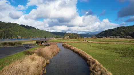 4k aerial drone shot gliding above water at dean creek in reedsport, oregon