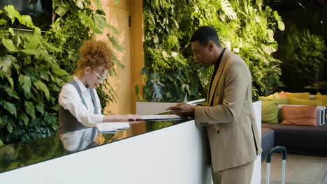 hombre de negocios afroamericano y recepcionista en un hotel