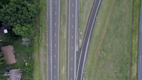 Vogelperspektive-Der-Luftdrohne-über-Die-Autobahn,-Die-Während-Der-Abendzeit-über-Die-Straßen-Der-Stadt-Führt