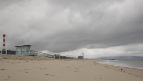 waves crash onto an empty beach on a foggy day, ominous and gloomy, storm coming