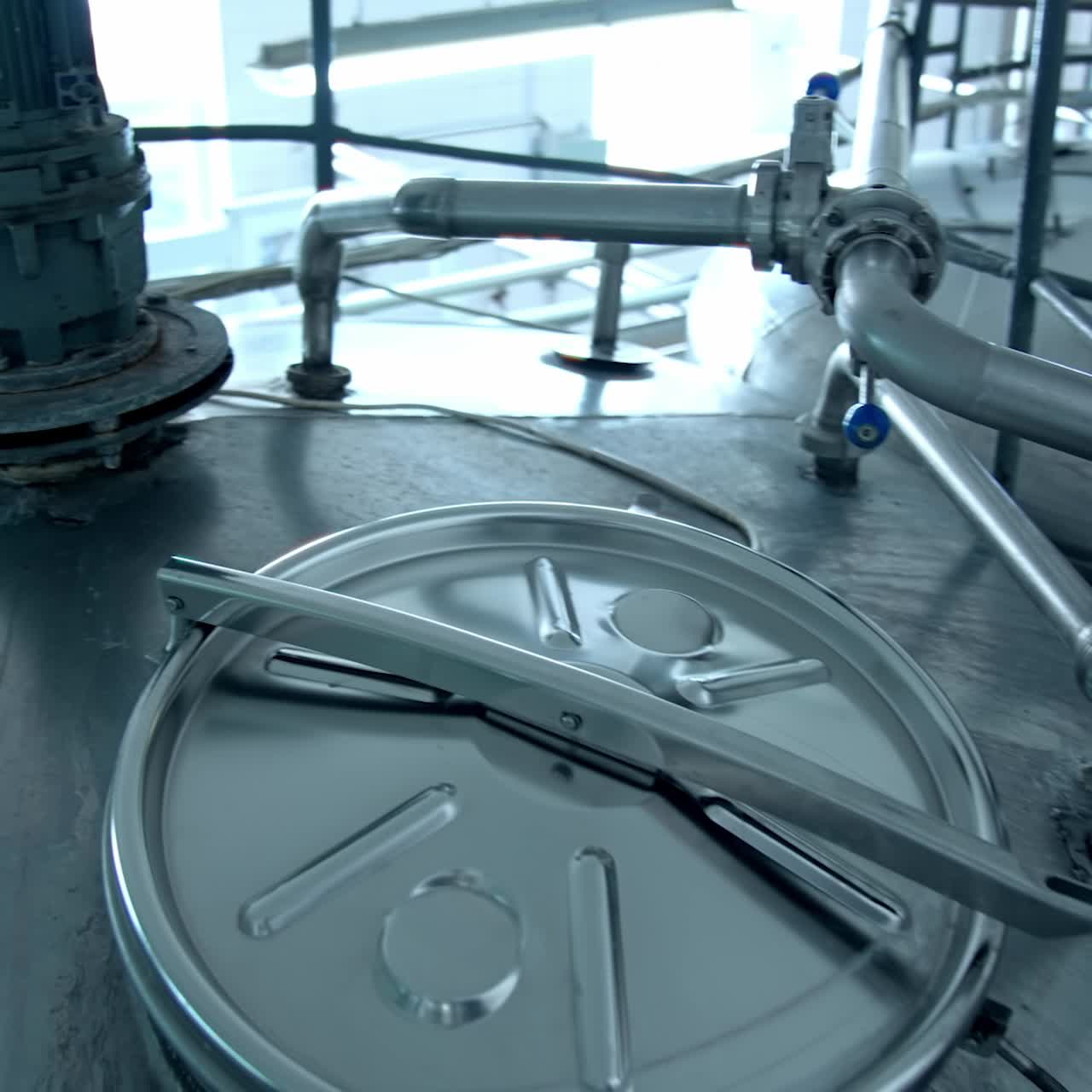 Innovative machinery on a dairy farm. Modern equipment on a milk factory. Metal containers for processing milk products