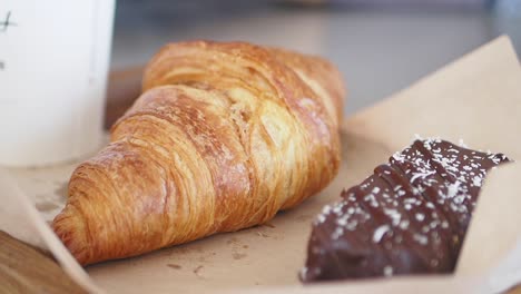 close-up of a croissant and a chocolate pastry on a tray