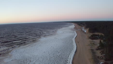 drone flight above partly frozen sea during dusk