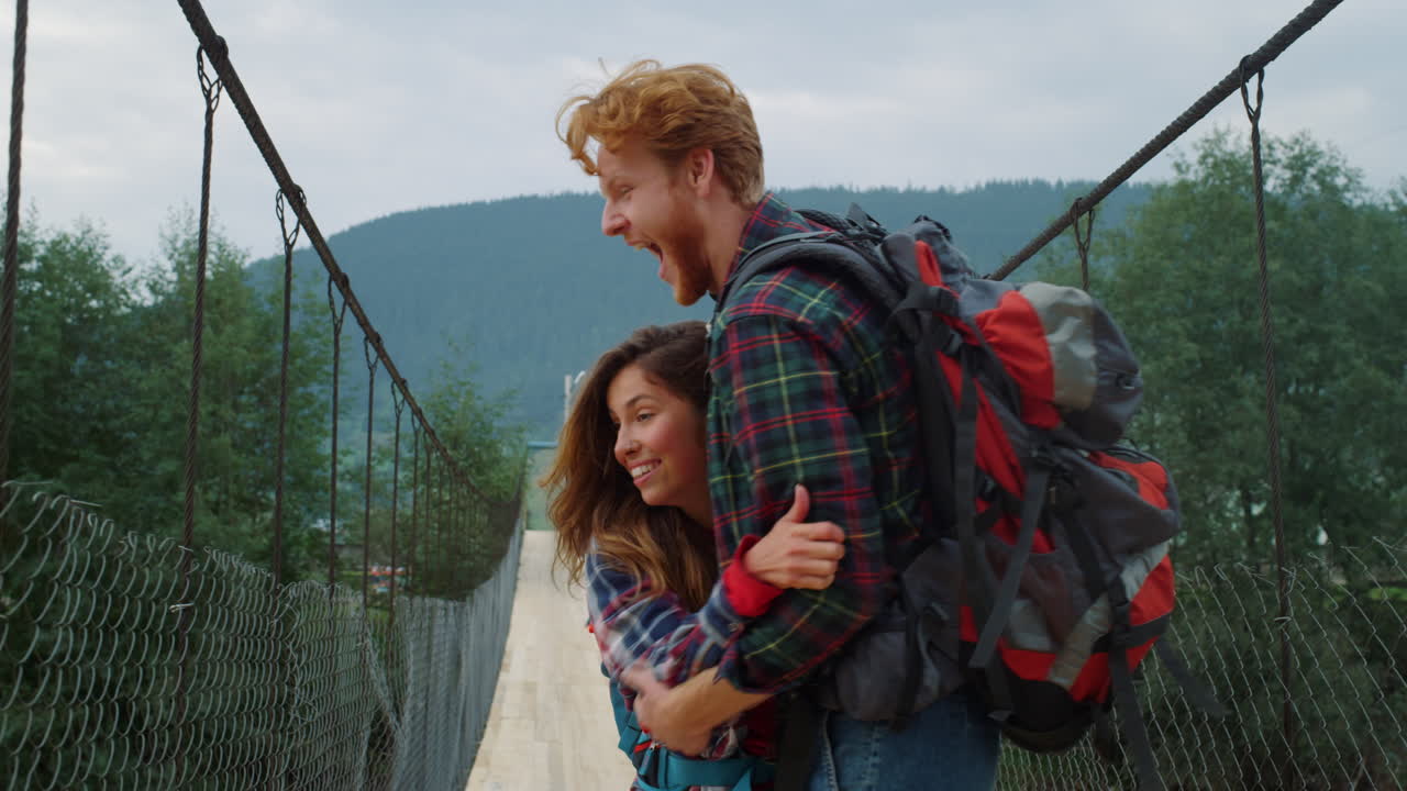viajeros alegres pareja animando en el puente de la montaña. concepto de estilo de vida activo