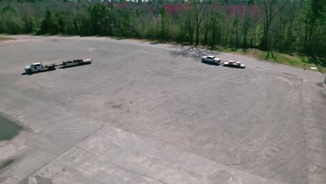 two white pickup trucks in a large empty parking
