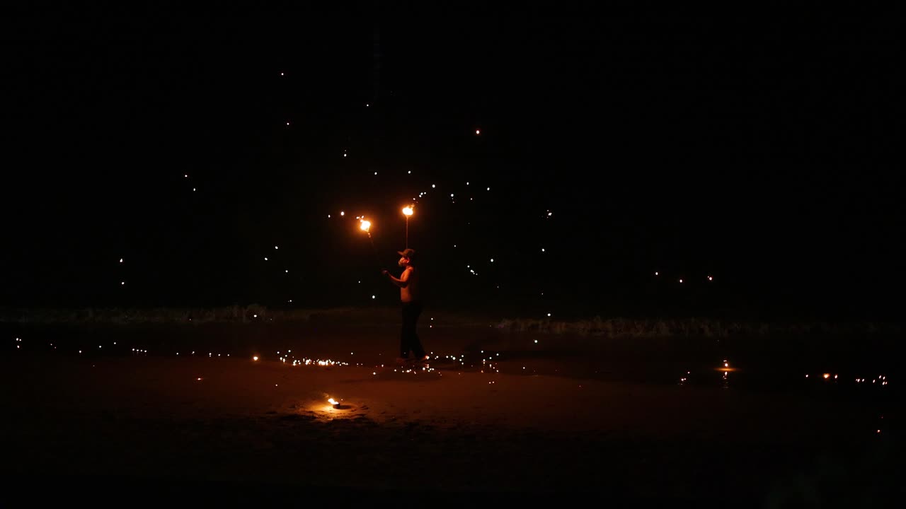 공연자 는 해변 에서 화재 기술 을 보여주고 있다