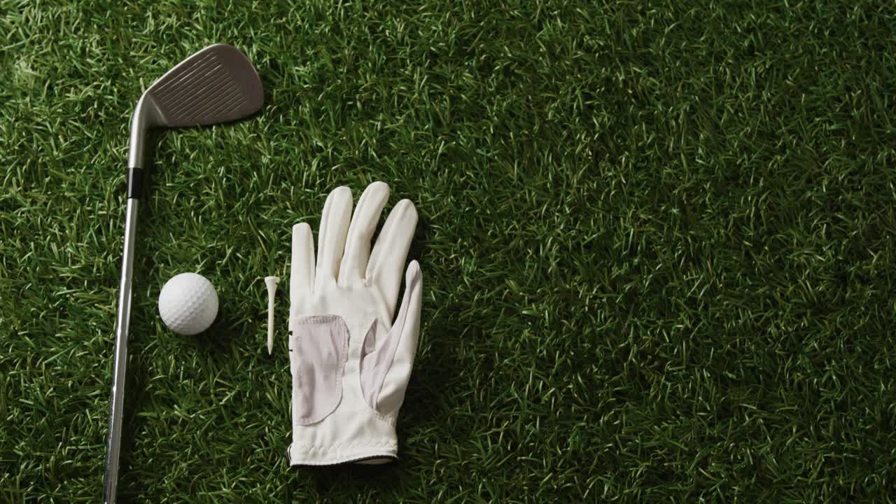 Primo piano di mazza da golf, pallina e guanto sull'erba, spazio per il testo, movimento rallentato.