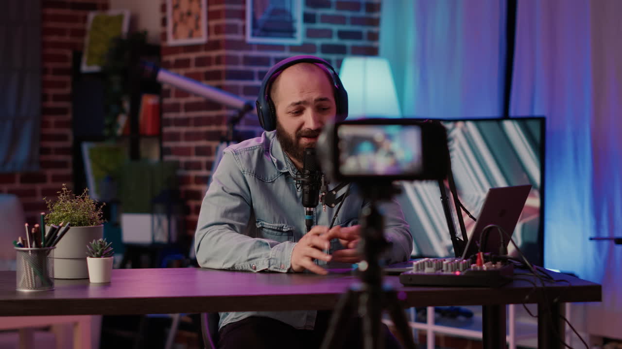 Selective focus on male content creator streaming live internet vlog using digital video camera