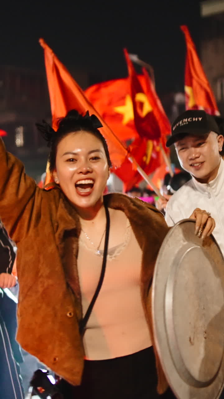 Pessoas comemorando com bandeiras e lambretas à noite