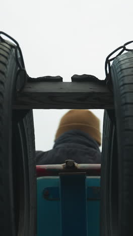 back view of a coach doing pull-ups on a workout equipment, as he pauses and moves his neck side to side
