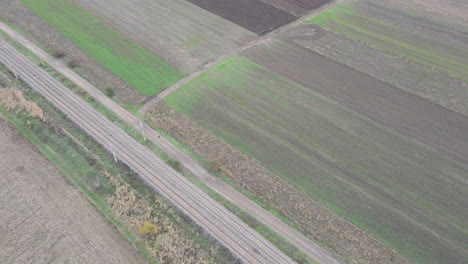 Drone-aerial-tilt-up-over-brown-bare-farmland-fields-to-reveal-overcast-sky