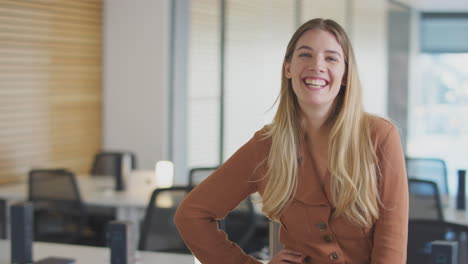 retrato de una mujer de negocios sonriente de pie en una oficina moderna de plan abierto