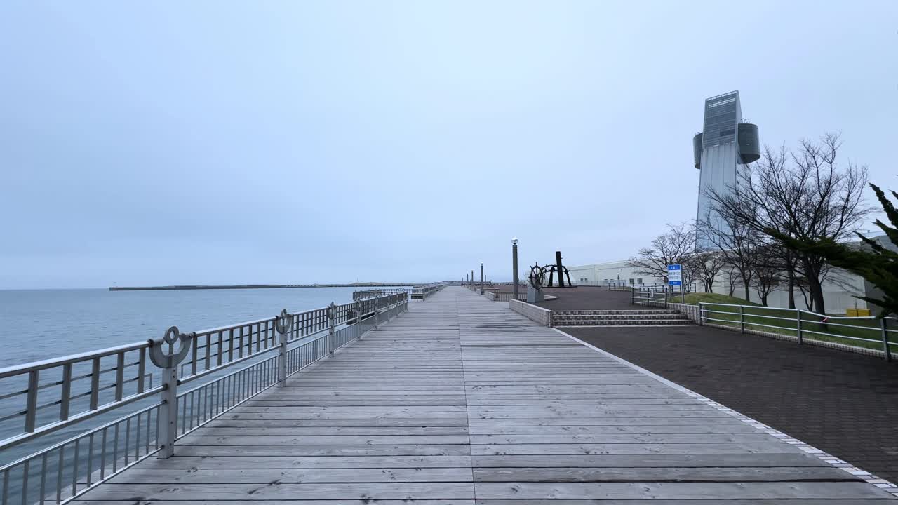 Wooden boardwalk along Aomori Bay with sea views and a modern observation tower