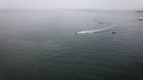 drone shot of a person wakeboarding in the ocean in a boat in lima peru