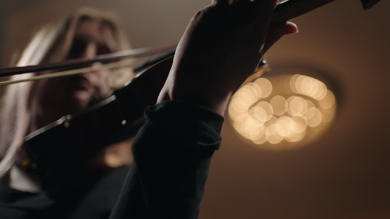 una violinista está tocando el violín en la sala de música una hermosa joven con un violín