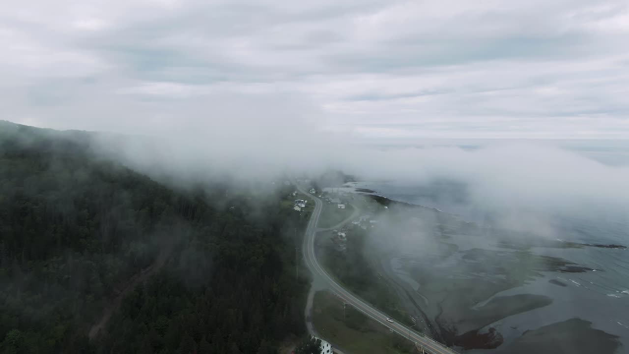 nubes temprano en la mañana sobre el tranquilo pueblo y el camino por las montañas chic-choc y el río san lorenzo en quebec, canadá