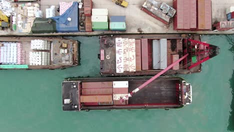 pequeñas barcazas de contenedores de tipo alimentador que operan en el muelle de pilar de hong kong