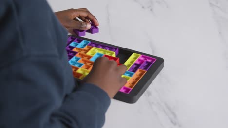 Close-Up-Of-Boy-On-ASD-Spectrum-Solving-Shape-Puzzle-On-White-Background-2