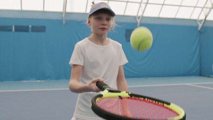 Young Girl Doing Tennis Ball Hits Exercise On Court