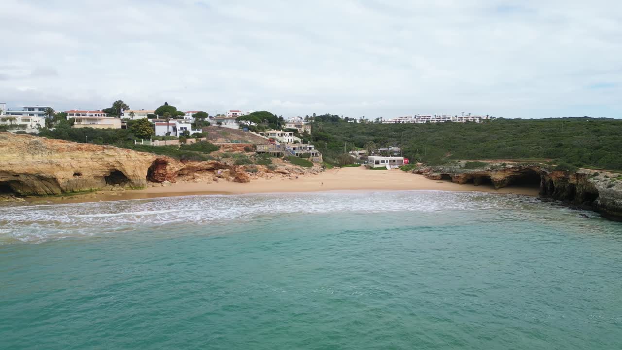 Playa apartada del Algarve con cuevas y casas en Ferragudo, Portugal, ambiente tranquilo
