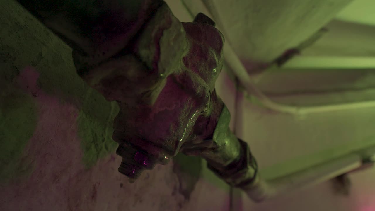 primer plano de tuberías y equipos oxidados en un lugar oscuro