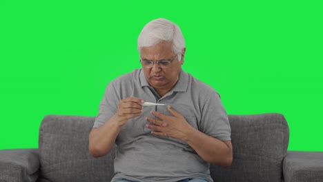 Sick-Indian-old-man-checking-fever-using-thermometer-Green-screen