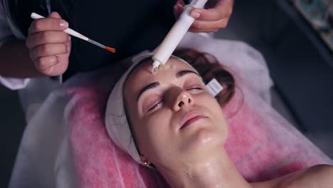 carboxytherapy for young woman in professional spa salon. young woman is lying on the couch while professional cosmetologist is