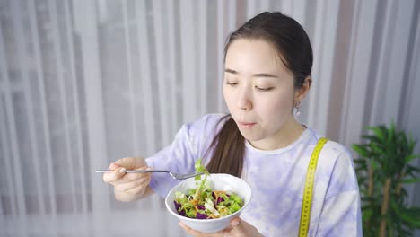 asian young woman on a healthy diet eats salad.