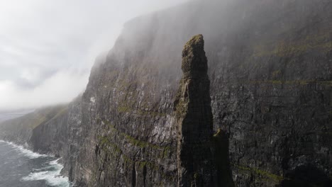 Kreisförmige-Drohnenaufnahmen-Des-Hexenfingers-In-Sandavagur-Auf-Der-Insel-Vagar-Auf-Den-Färöer-Inseln