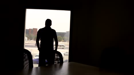 a man stands and gazes out of the window in a modern office, deep in thought. perfect for business, reflection, decision-making, and professional lifestyle projects